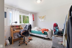 Wall-to-wall carpeting and white walls enhance this room, featuring two large windows - 