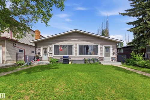 Ranch-style exterior with light-toned siding and stone veneer accents - 7412/7414 83 Avenue, Edmonton, AB 