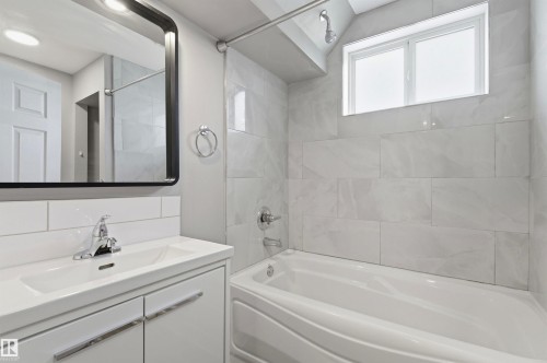 Modern bathroom vanity with integrated sink and chrome faucet - 7412/7414 83 Avenue, Edmonton, AB 