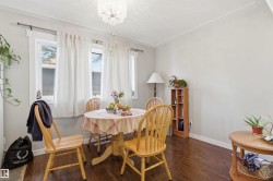Dining area featuring wood-finish flooring, a crystal chandelier, and light gray wall paint - 