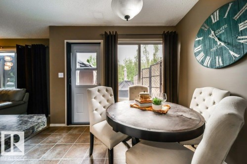 Open concept living area with tiled flooring, a light-colored ceiling fixture, and a large window with privacy screening - 8507 2 Avenue, Edmonton, AB - Indoor Photo Showing Dining Room