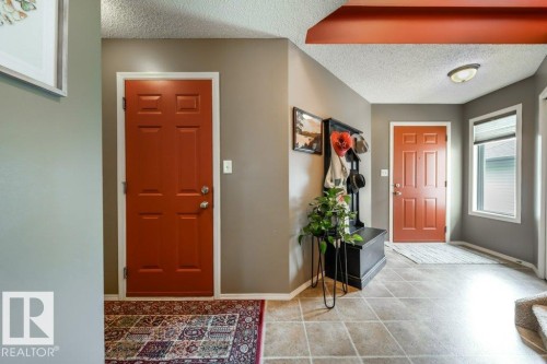 Entryway with terracotta-painted panel doors, neutral wall tones, and tiled flooring - 8507 2 Avenue, Edmonton, AB - Indoor Photo Showing Other Room