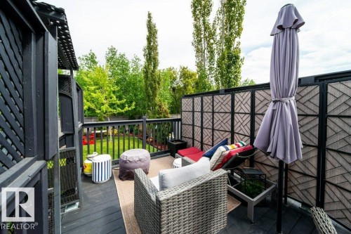 Outdoor deck featuring dark wood flooring, a matching wood railing, and a slatted privacy screen - 8507 2 Avenue, Edmonton, AB - Outdoor With Deck Patio Veranda With Exterior