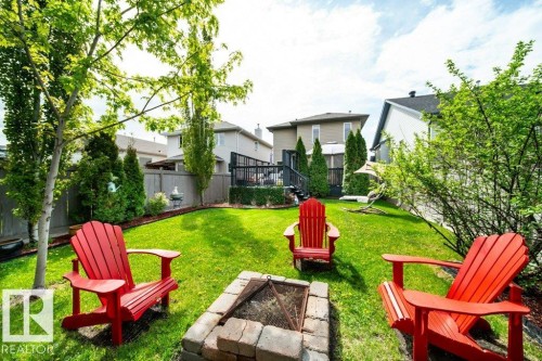 Expansive green lawn with a built-in stone fire pit - 8507 2 Avenue, Edmonton, AB - Outdoor With Backyard