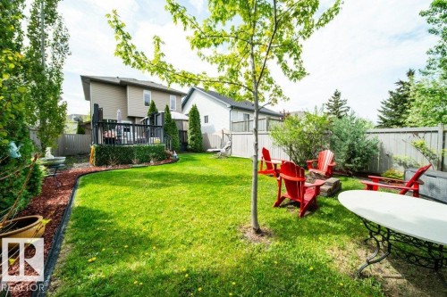 Spacious backyard featuring a multi-level wood deck with black railings, a fire pit area, mature trees, and privacy fencing - 8507 2 Avenue, Edmonton, AB - Outdoor With Deck Patio Veranda With Backyard