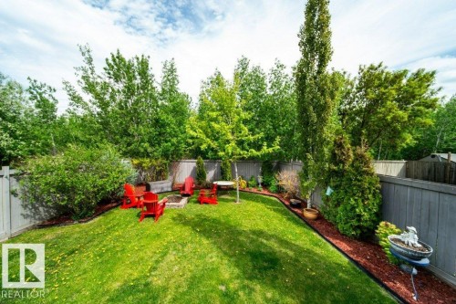 Expansive green lawn with a built-in fire pit area and surrounding garden beds - 8507 2 Avenue, Edmonton, AB - Outdoor