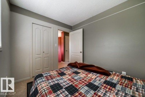 Carpeted room featuring neutral-toned walls, white trim, and a textured ceiling - 8507 2 Avenue, Edmonton, AB - Indoor Photo Showing Bedroom