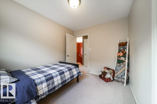 Neutral tone walls, ceiling-mounted light fixture, and light-colored carpet flooring - 8507 2 Avenue, Edmonton, AB - Indoor Photo Showing Bedroom