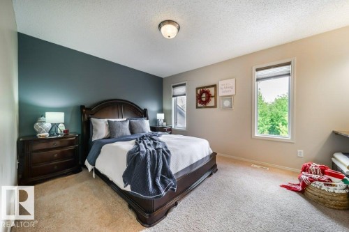 Carpeted room featuring a dark accent wall and two windows with blinds - 8507 2 Avenue, Edmonton, AB - Indoor Photo Showing Bedroom