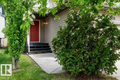Red entry door with black stairs, concrete walkway, and established landscaping - 8507 2 Avenue, Edmonton, AB - Outdoor