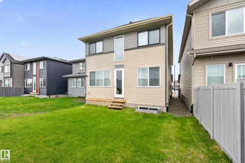 Rear exterior with two-story design featuring beige siding and dark trim - 19286 22A Avenue, Edmonton, AB 