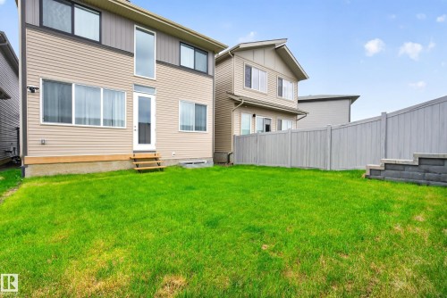 Expansive green lawn with a privacy fence and stone retaining wall - 19286 22A Avenue, Edmonton, AB 
