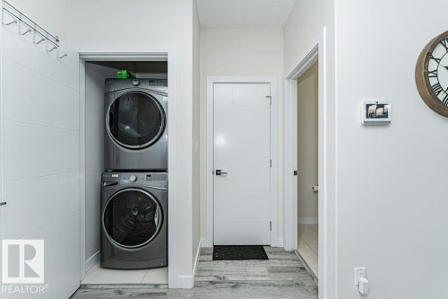 Full-size stacked washer and dryer in a dedicated laundry closet - 721 Berg Loop, Leduc, AB - Indoor Photo Showing Laundry Room