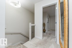 Carpeted staircase with white balusters and black metal spindles - 