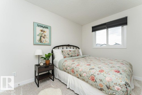 Bedroom featuring light-colored walls and a window with a dark roller shade - 721 Berg Loop, Leduc, AB - Indoor Photo Showing Bedroom