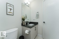 Bathroom featuring a vanity with a dark stone countertop, an integrated rectangular sink, and chrome fixtures - 