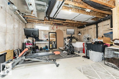 Unfinished basement area featuring exposed ceiling joists and ductwork, a single window, and concrete flooring - 721 Berg Loop, Leduc, AB - Indoor Photo Showing Basement