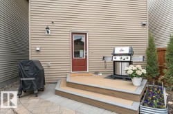 Composite deck with two steps and integrated gray trim, leading to a red entry door - 