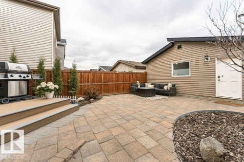 Expansive paver patio with a wood-finish composite deck - 721 Berg Loop, Leduc, AB - Outdoor With Exterior