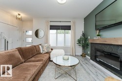 Living area featuring a contemporary fireplace with hexagonal tile surround and wood mantel - 