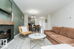 Open-concept living area featuring wood-finish flooring, a contemporary fireplace with hexagonal tile surround and a wood mantel, and recessed lighting - 