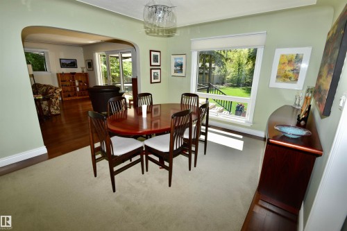 Dining area featuring a prominent window, light green walls, and a light-colored carpet - 6 St George'S Crescent, Edmonton, AB 