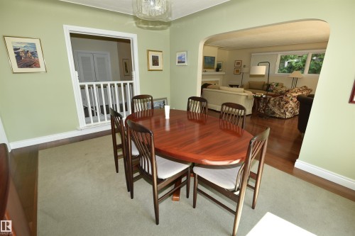 Dining area featuring light green walls, a white crown molding, and a chandelier - 6 St George'S Crescent, Edmonton, AB 