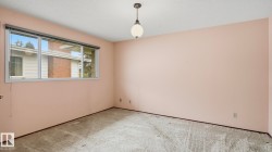 Interior room featuring neutral-toned carpeting and pastel pink walls - 