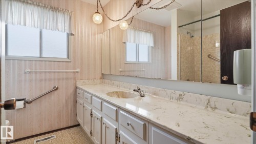 Bathroom with a single vanity featuring a white cabinetry base and a light-toned countertop with an integrated sink - 7408 40 Avenue, Edmonton, AB 