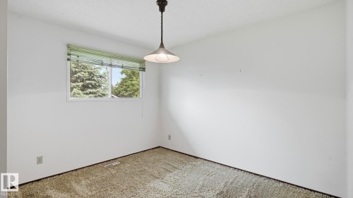 Neutral wall paint, textured ceiling, a single window with blinds, and existing ceiling light fixture - 7408 40 Avenue, Edmonton, AB 