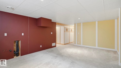 Finished lower level space with light gray carpeting and a white acoustic tile ceiling - 7408 40 Avenue, Edmonton, AB 