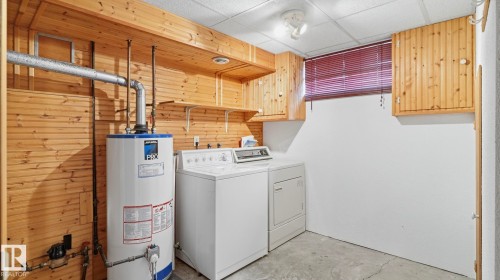 Dedicated utility space featuring a water heater, washer, and dryer - 7408 40 Avenue, Edmonton, AB 