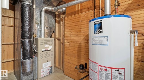 HVAC system and hot water heater installation featuring wood paneling - 7408 40 Avenue, Edmonton, AB 