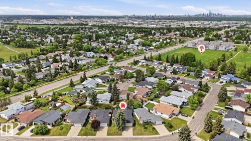 Aerial perspective showcasing a residential neighborhood with detached homes, mature trees, and a nearby roadway - 7408 40 Avenue, Edmonton, AB 