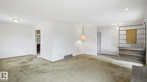 Open concept living area with carpeting and white painted walls - 7408 40 Avenue, Edmonton, AB 