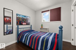Room featuring a single window with a privacy shade, dark wood-finish flooring, white baseboards, and light-toned walls - 