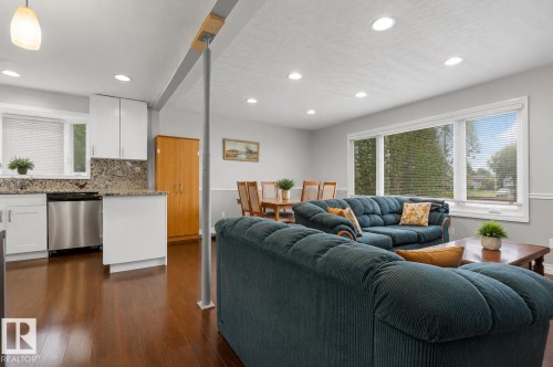 Open-concept living space featuring wood-finish flooring, recessed lighting, and a large picture window - 11234 40 Avenue, Edmonton, AB 
