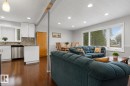 Open-concept living space featuring wood-finish flooring, recessed lighting, and a large picture window - 11234 40 Avenue, Edmonton, AB 