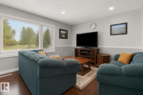 Living area with hardwood-finish flooring and light gray walls featuring white trim - 11234 40 Avenue, Edmonton, AB 