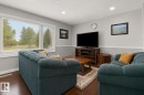 Living area with hardwood-finish flooring and light gray walls featuring white trim - 11234 40 Avenue, Edmonton, AB 