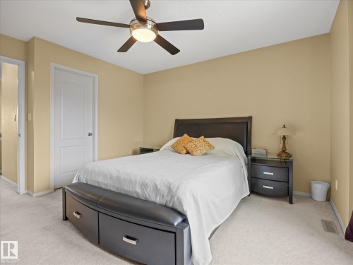 Carpeted room featuring a ceiling fan with integrated lighting, neutral wall tones, and a solid white door - #88 5001 62 St, Beaumont, AB - Indoor Photo Showing Bedroom