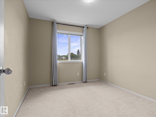 Neutral-toned wall finishes complemented by light-colored carpeting - #88 5001 62 St, Beaumont, AB - Indoor Photo Showing Other Room