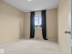 Carpeted room featuring a white window frame, light beige wall paint, white baseboards, and a semi-flush ceiling light - 