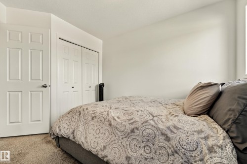 Plush carpeted flooring, neutral wall tones, a paneled interior door, and a bi-fold closet door - 20507 128 Avenue, Edmonton, AB 