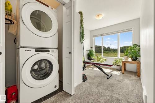 Dedicated laundry closet with a stacked washer and dryer unit - 20507 128 Avenue, Edmonton, AB 