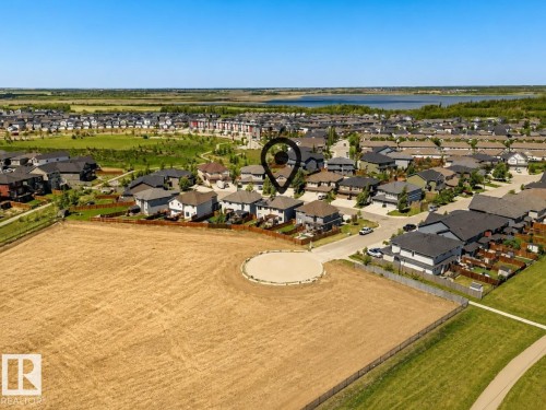 Aerial perspective showcasing a residential development with a prominent lake in the background - 20507 128 Avenue, Edmonton, AB 
