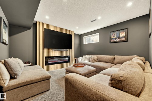 Accent wall featuring vertical wood paneling and an integrated electric fireplace - 20507 128 Avenue, Edmonton, AB 