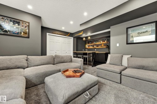 Recreation room featuring recessed lighting, a built-in bar, wood-finish shelving, pendant lighting, and a neutral color palette - 20507 128 Avenue, Edmonton, AB 
