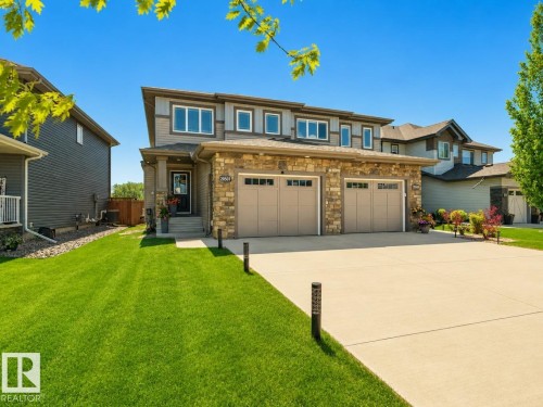 Two-story residence featuring a stone and siding exterior, a three-car garage, and a concrete driveway - 20507 128 Avenue, Edmonton, AB 