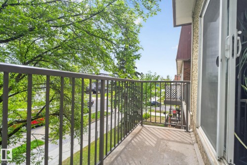 Private balcony featuring a gray metal railing, concrete flooring, and an adjacent sliding glass door - 204 12404 114 Avenue, Edmonton, AB - Outdoor With Balcony With Exterior